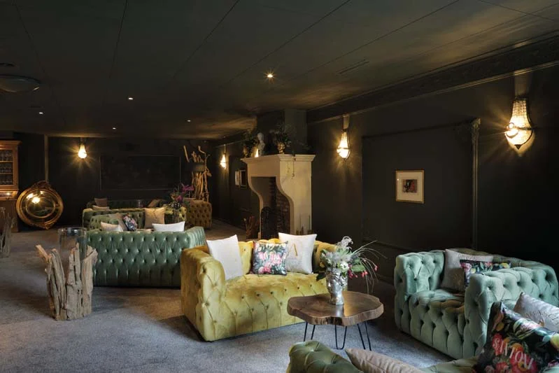 Foto eines sehr noblen Restaurants mit gemütlichen Sofas - dunkel gestrichen ist